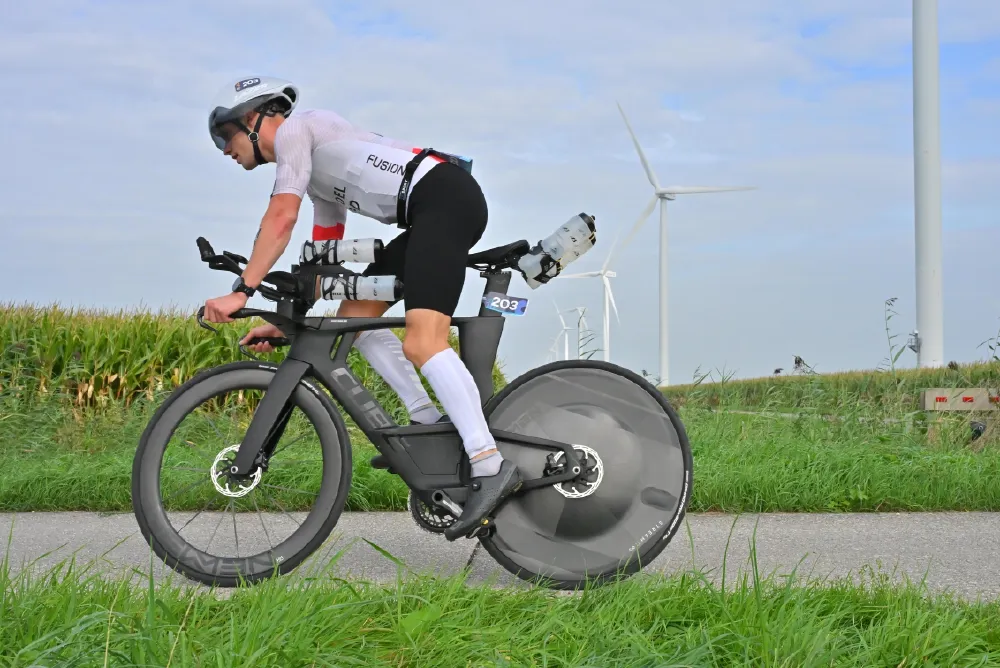 Zijaanzicht van Danny Verdel op de tijdritfiets met windmolens erachter tijdens Challenge Almere-Amsterdam 2026