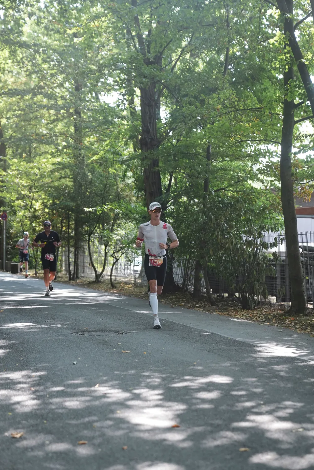 Danny Verdel running on a shaded path through the trees during Ironman 70.3 Duisburg 2026