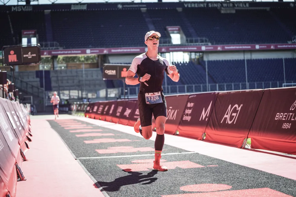 Danny Verdel on the finish carpet in the stadium at Ironman 70.3 Duisburg 2025
