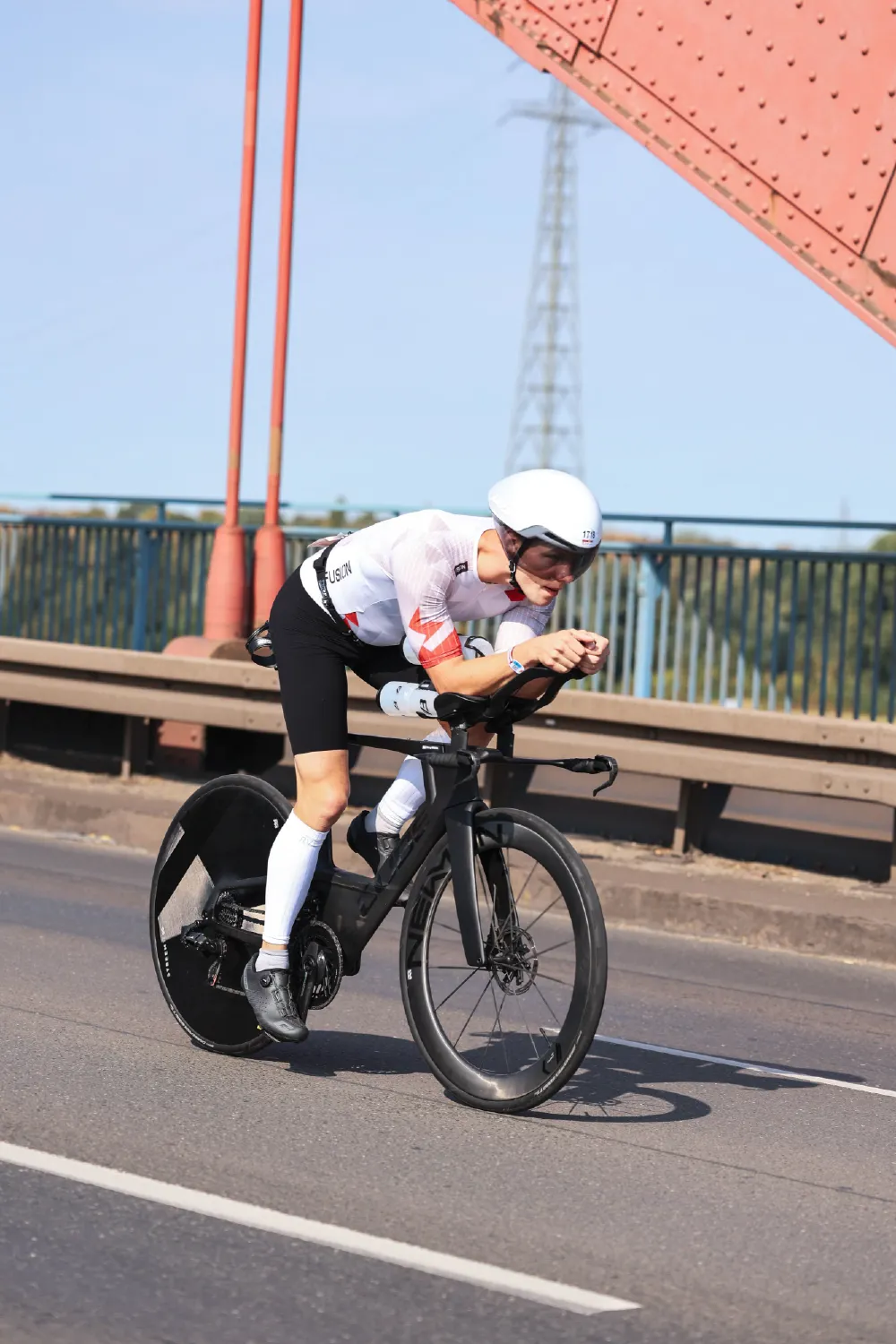Danny Verdel crossing a red steel bridge in aero position during Ironman 70.3 Duisburg 2026