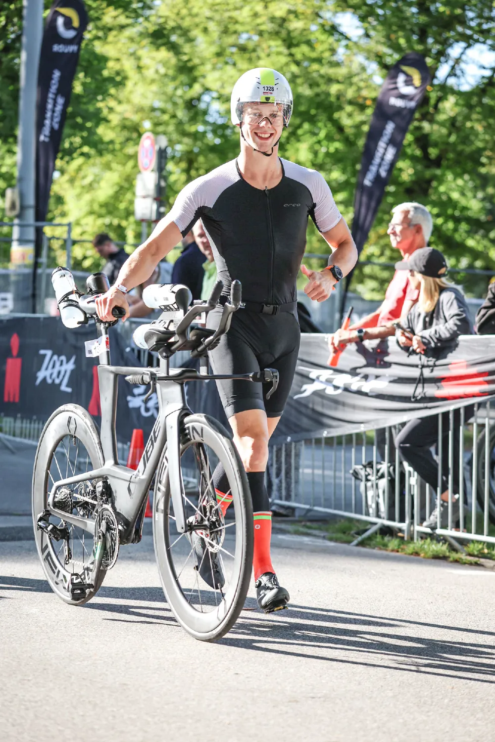 Danny Verdel smiling while pushing the bike through transition at Ironman 70.3 Duisburg 2025