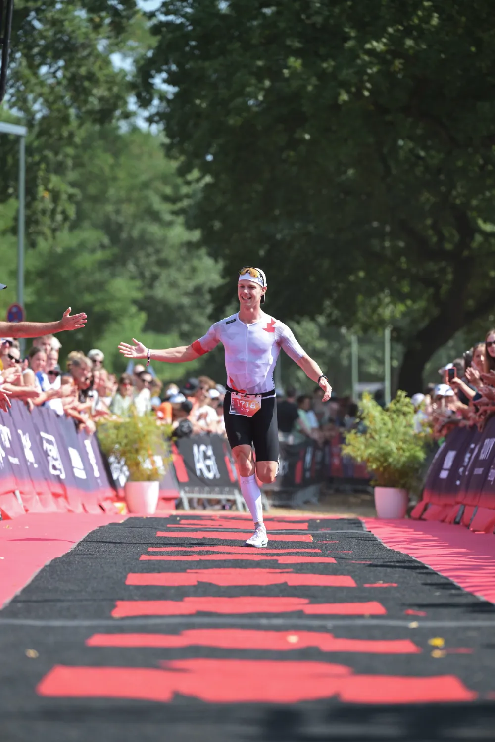 Danny Verdel high-fiving spectators on the finish carpet at Ironman 70.3 Duisburg 2026