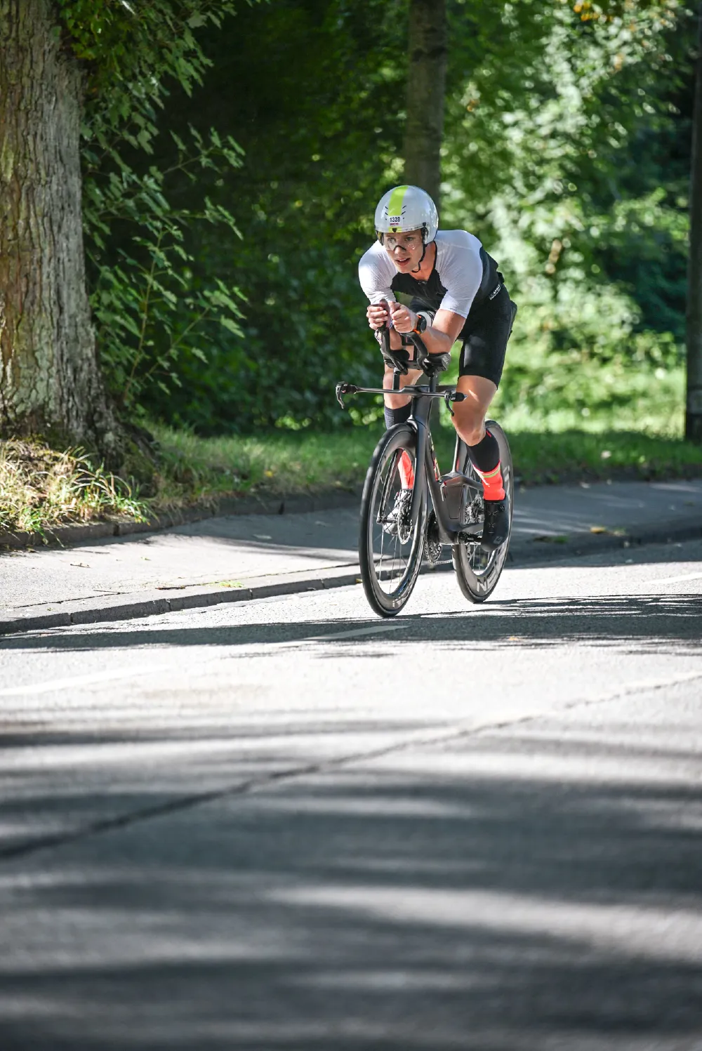 Danny Verdel riding in aero position on a shaded road during Ironman 70.3 Duisburg 2025