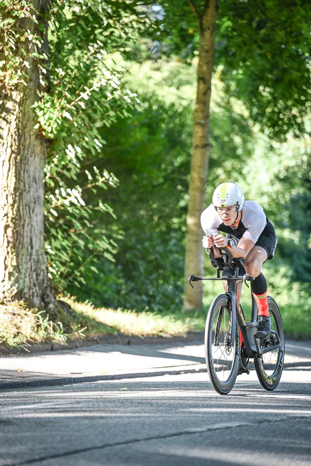 Danny Verdel in aero position on a tree-lined road during the bike leg of Ironman 70.3 Duisburg 2025